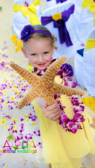 Smiling flower girl holding up a big starfish